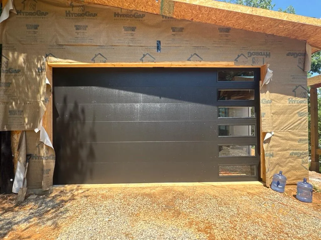 Modern contemporary residential garage door with clean panel lines installed on an East Tennessee home
